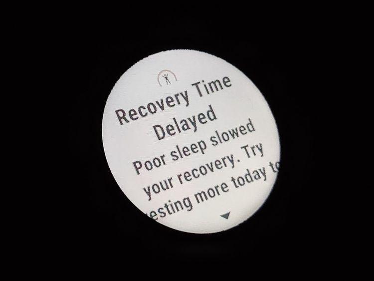 Digital watch screen reading "recovery time delayed due to poor sleep"